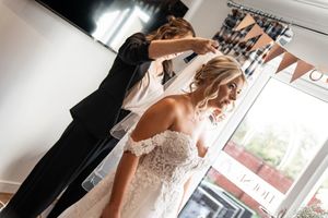 Getting ready sequence showing final touches of wedding dress and veil preparations.