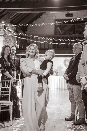 Wedding guests dance and celebrate together in a rustic barn venue decorated with string lights.