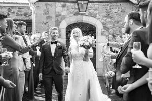 Wedding guests gather outside stone venue for celebration festivities.