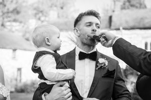 Groomsmen in formal attire celebrate during wedding reception with energetic poses.