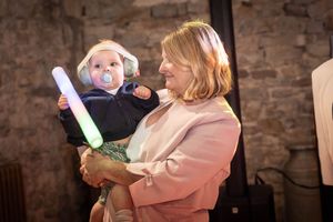 Wedding celebration with festive lighting and guests in a rustic stone venue.