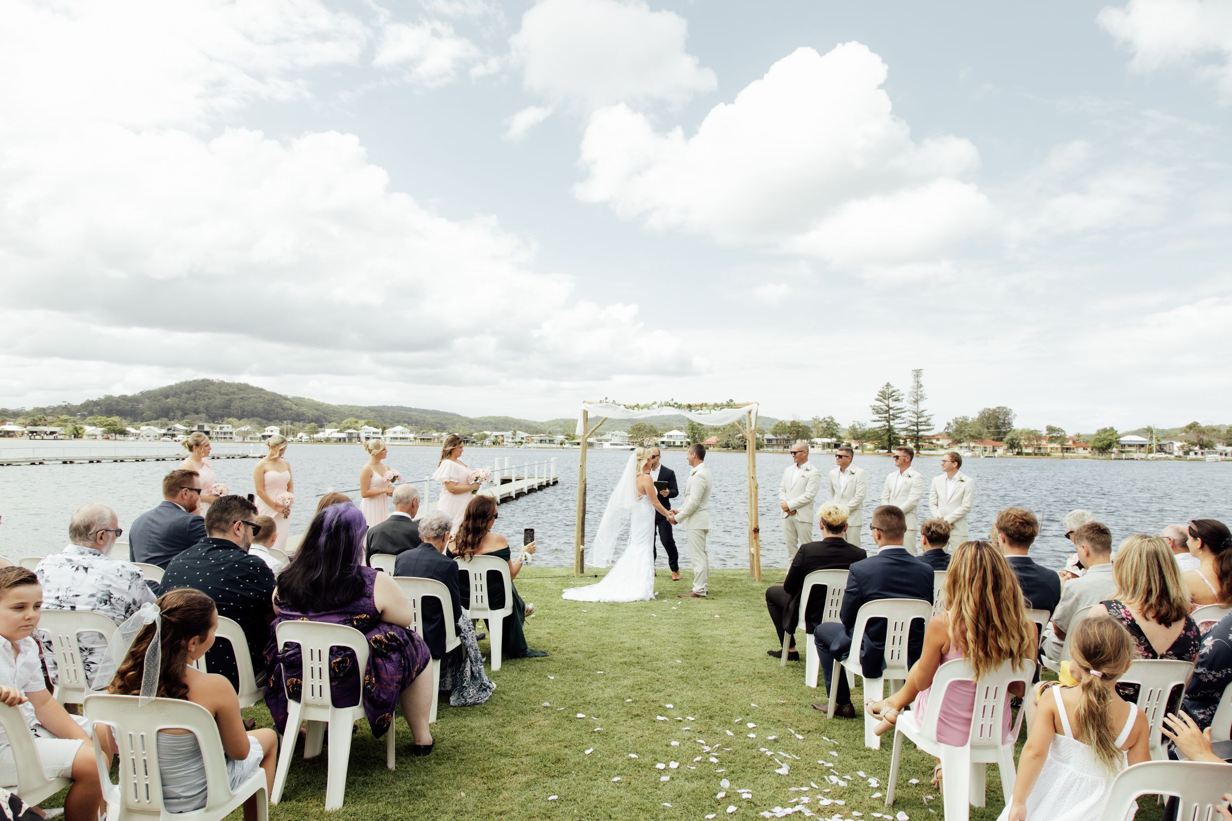 A panoramic collage of a seaside wedding ceremony showing chairs set up on grass overlooking the ocean.