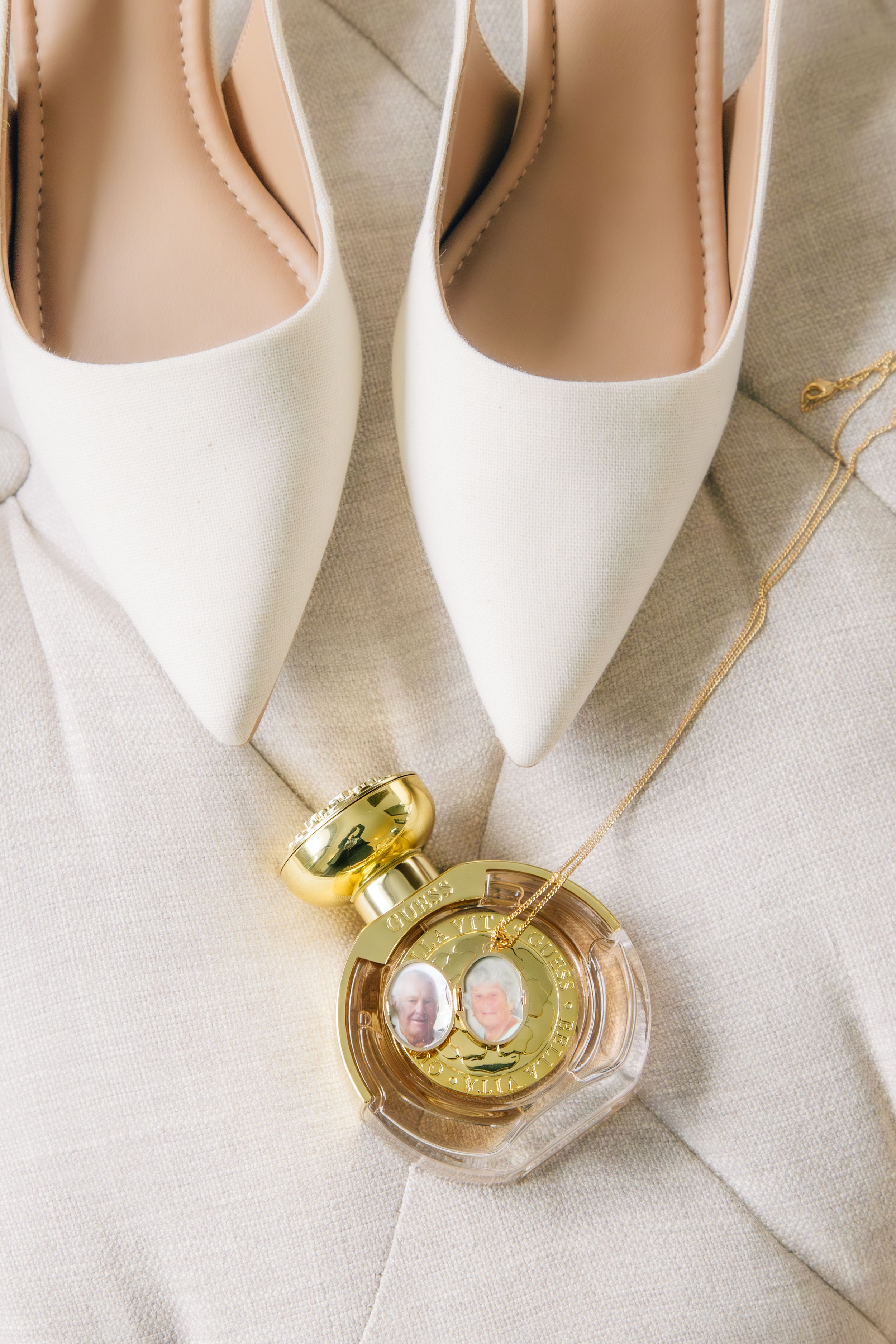 White high heel shoes arranged in a row with golden jewelry accessories on a white textured background.