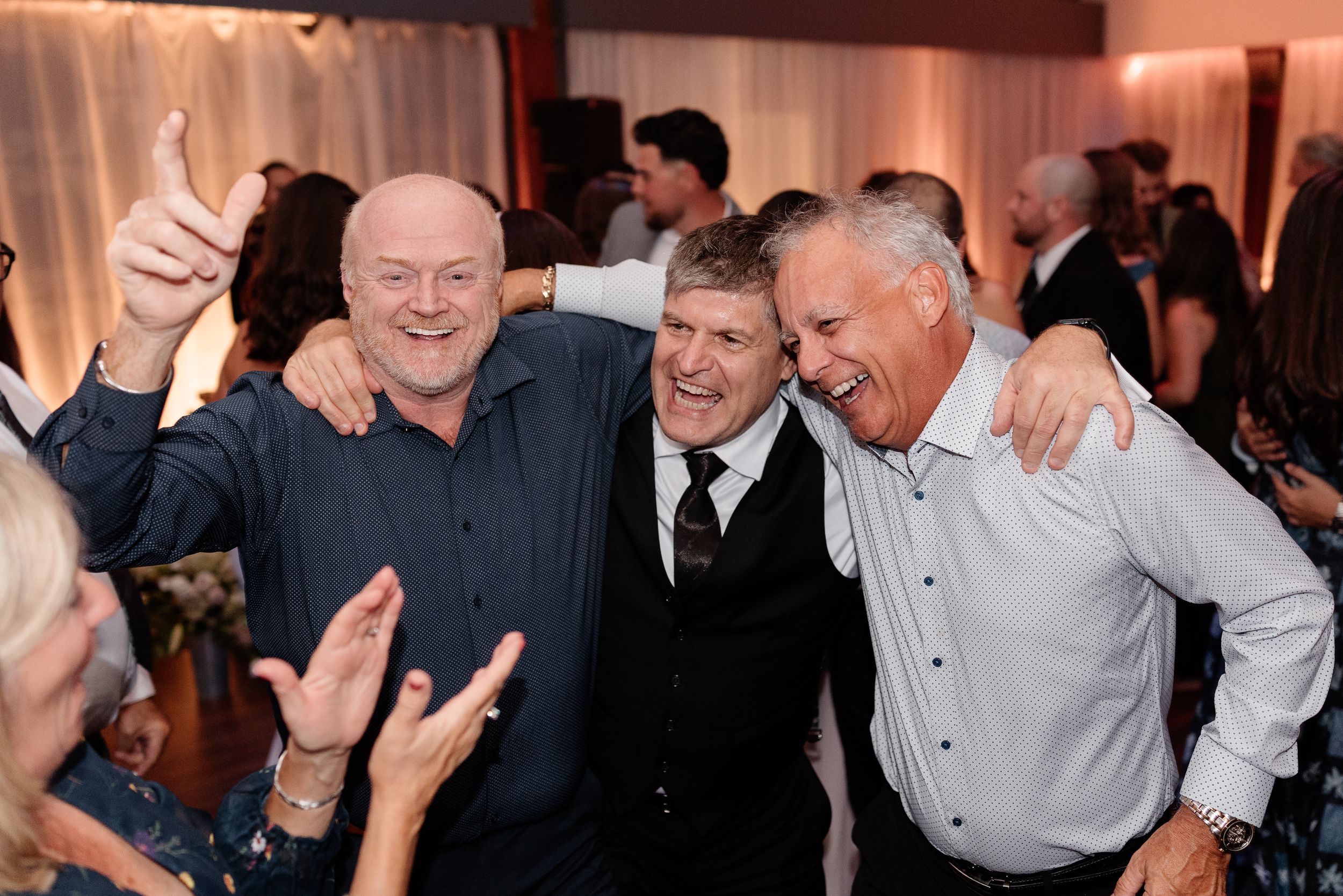 A group of people dancing and celebrating at a lively indoor event or party.