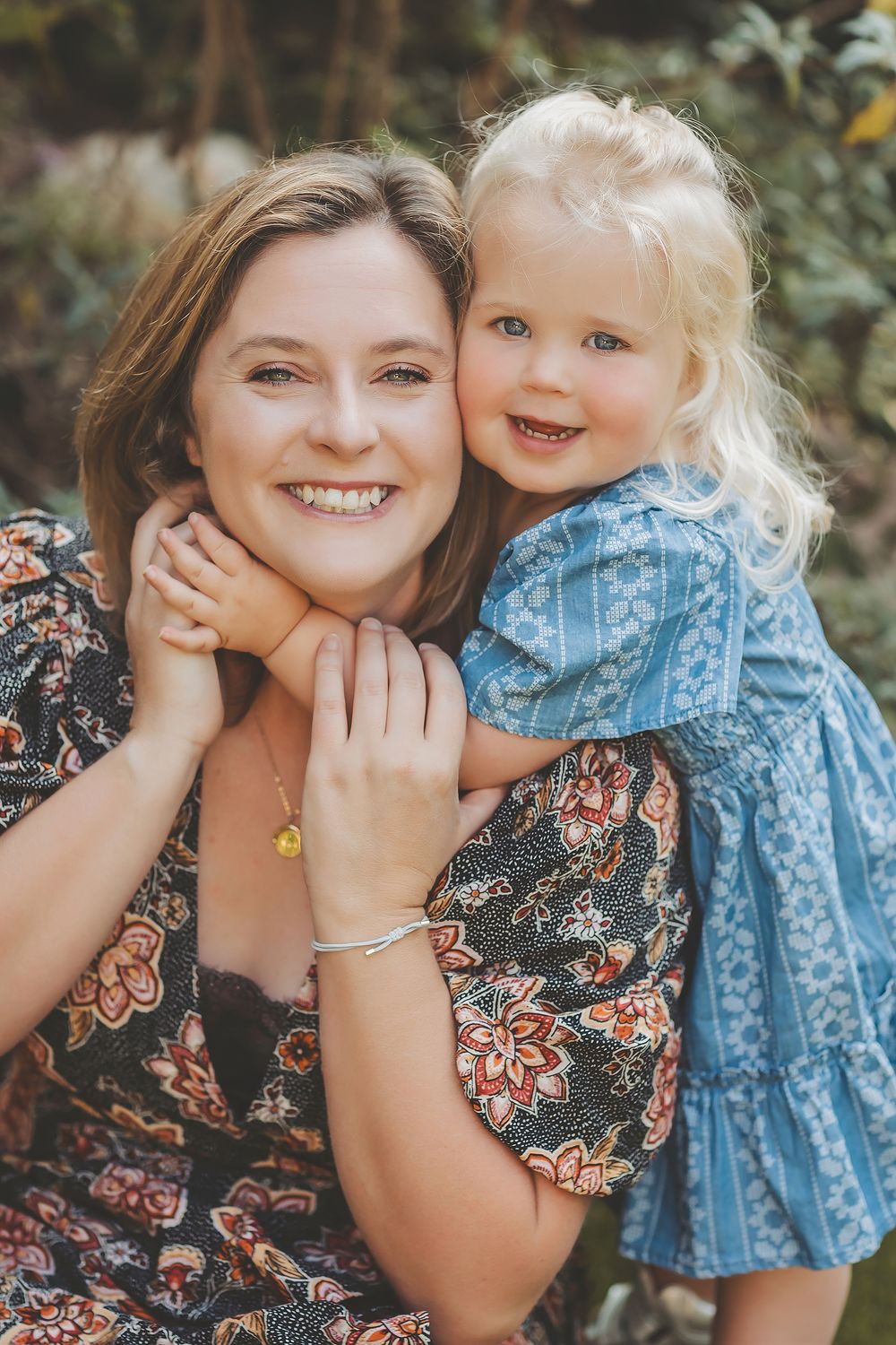 A series of candid outdoor portrait photos showing joyful embraces and sweet moments in matching floral and blue outfits.