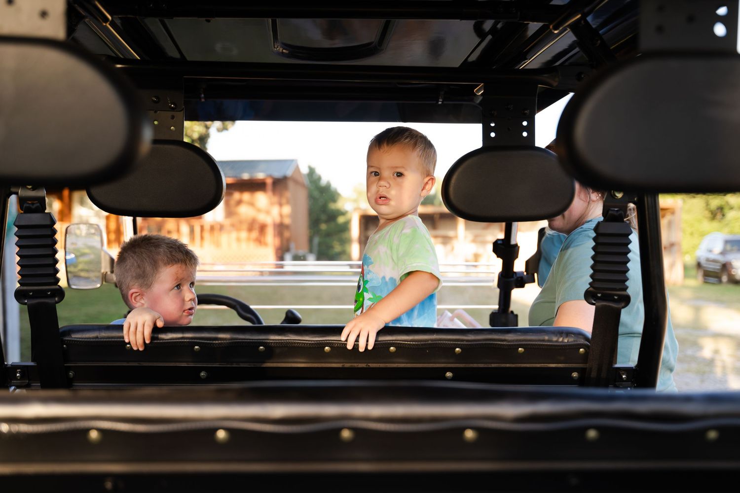 Farm family loading up in ATV to feed the cows at sunset, during family photography session outside of Tulsa, Oklahoma