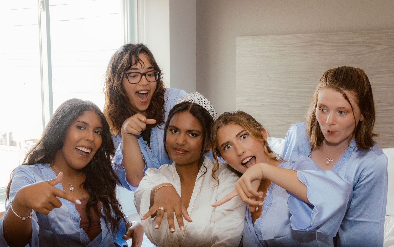 Bridesmaids in matching blue robes sharing a joyful moment together.