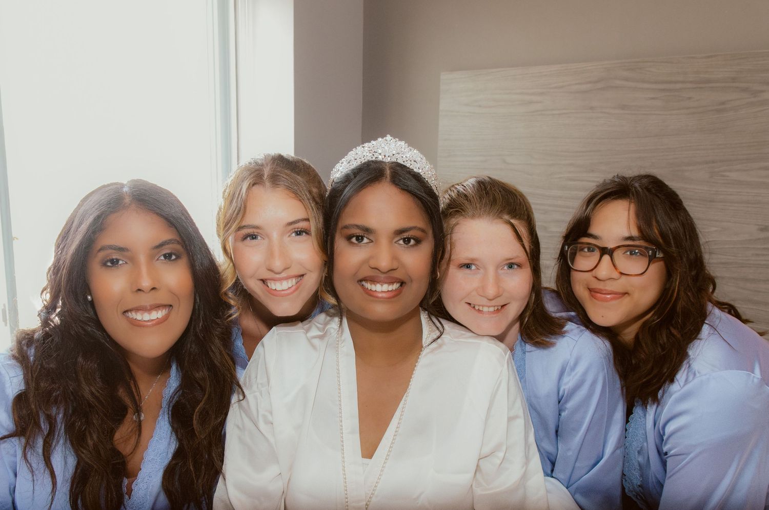 Wedding party smiling together in matching getting-ready outfits.