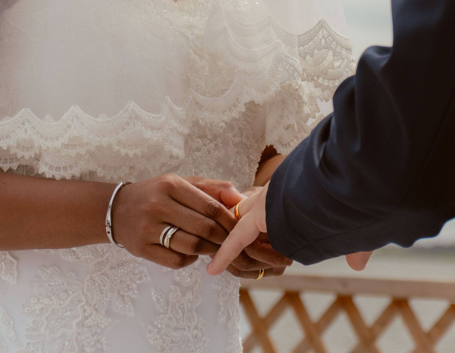 Close-up of hands exchanging rings during a wedding ceremony.