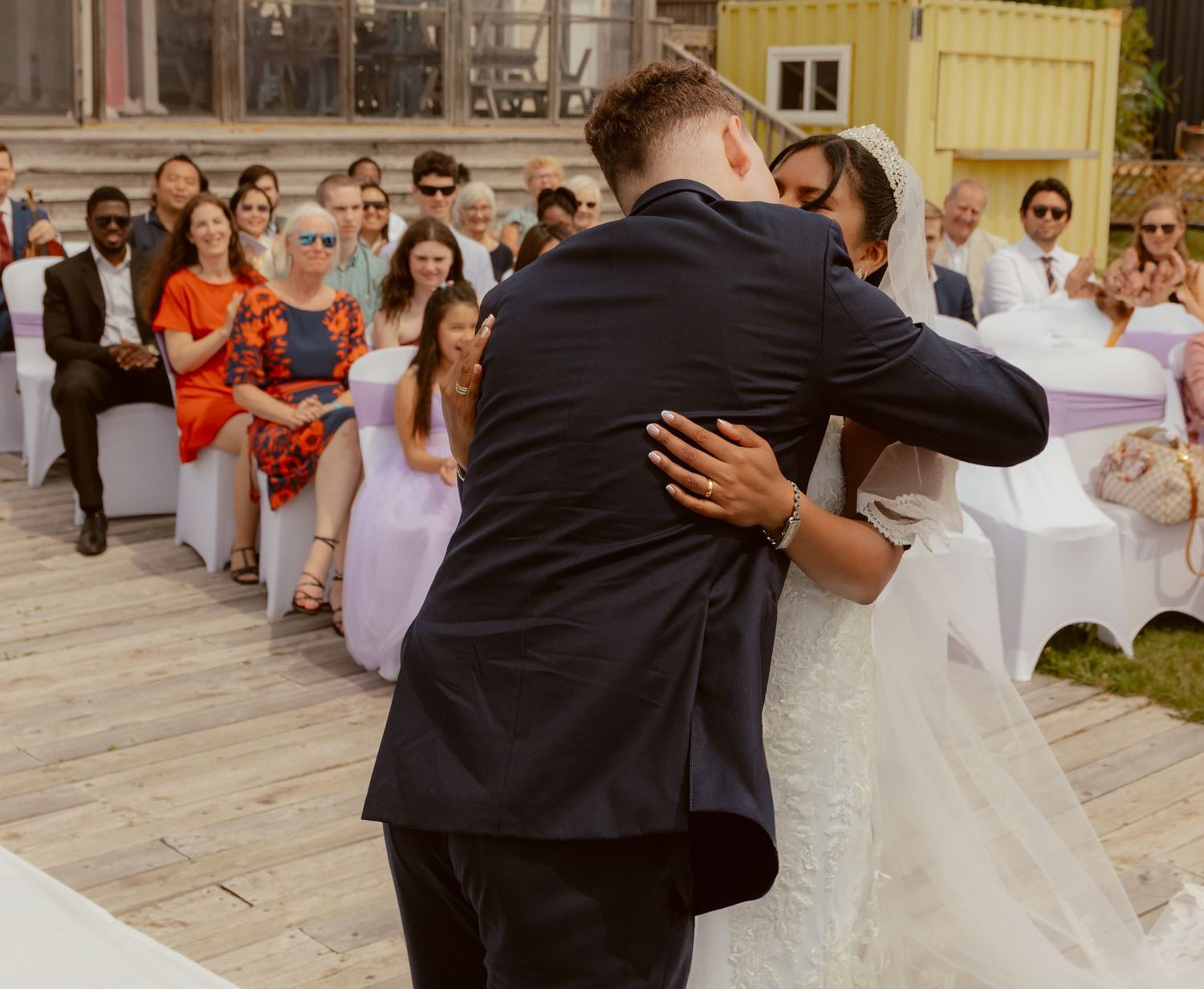 Couple shares first dance surrounded by guests at outdoor reception.