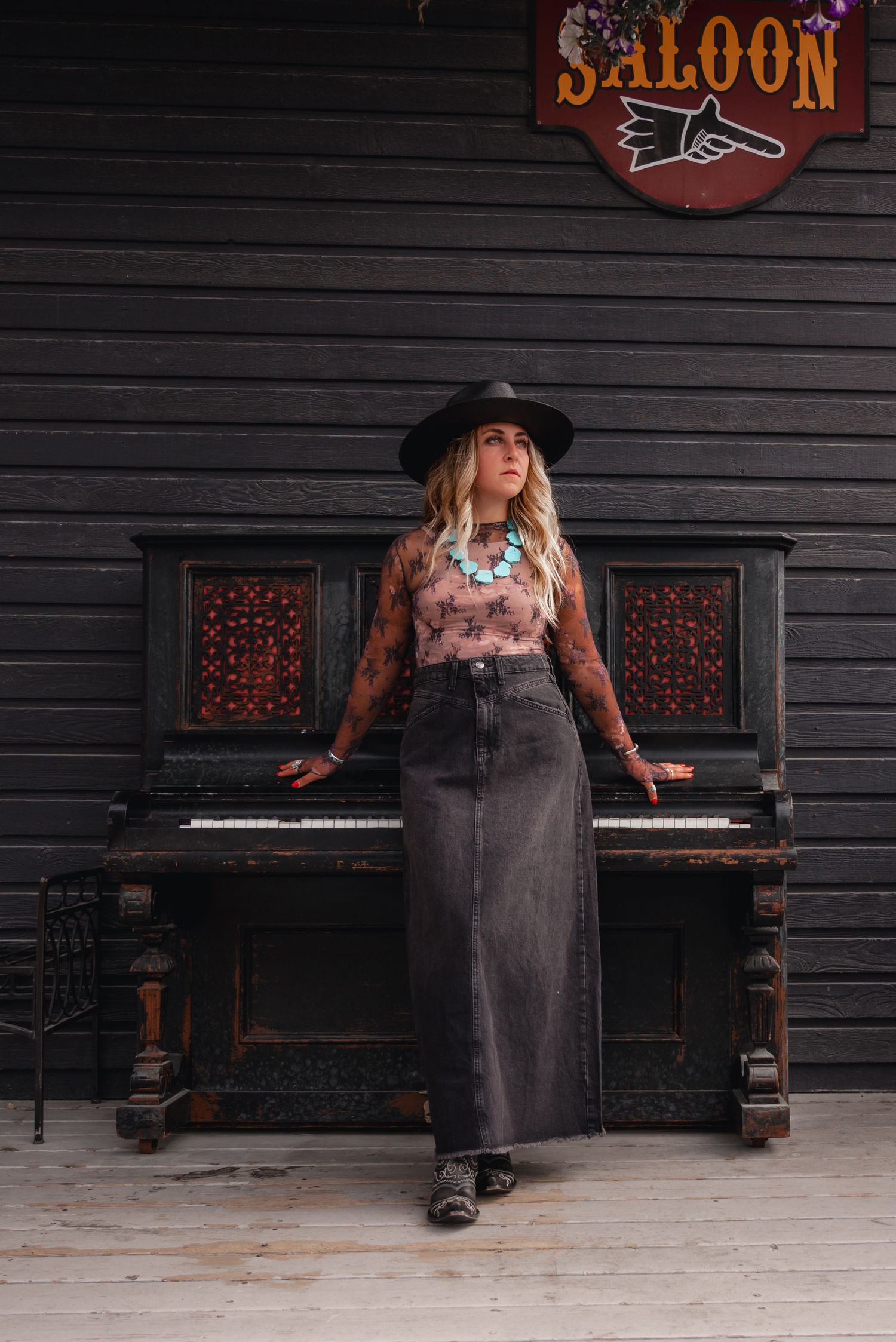 Model posing with a piano at Texas Gate Bar & Grill in Cochrane, wearing a Free People lace top.