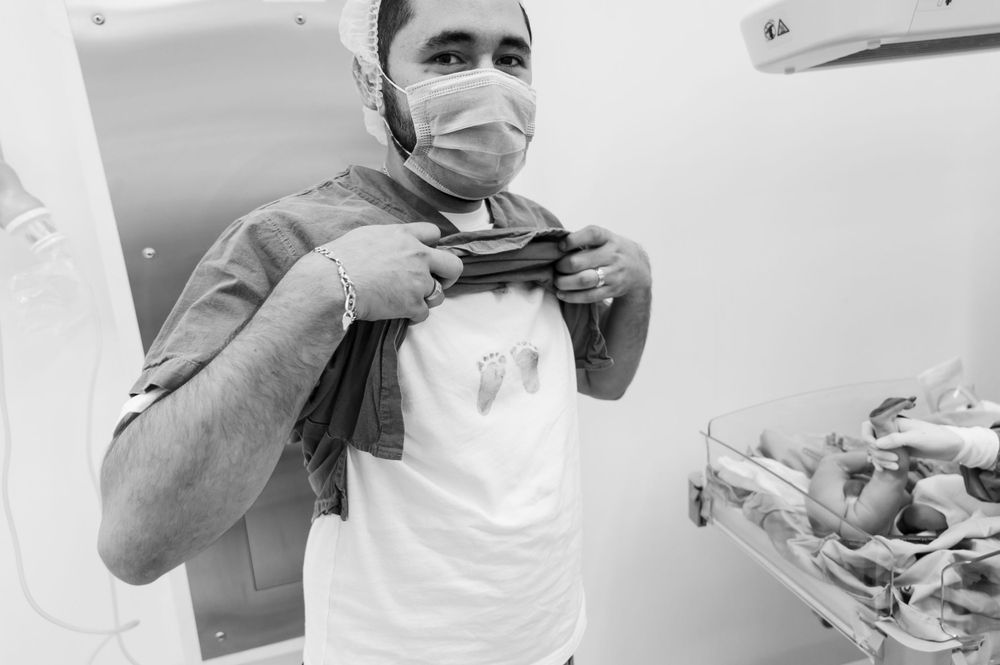 Healthcare workers in protective gear performing medical procedure.