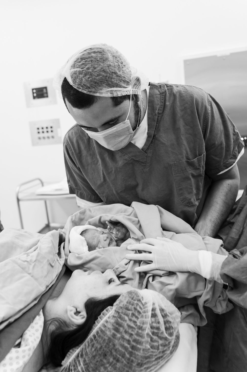 Medical professionals in surgical attire working together during operation.