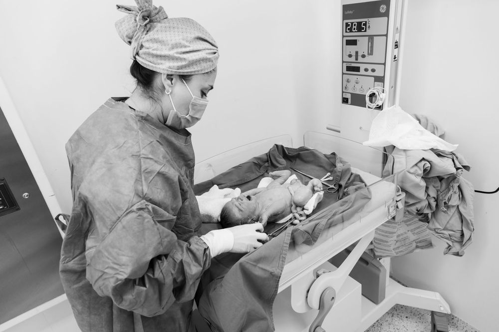 Healthcare professionals in protective gear working together during a surgical procedure.