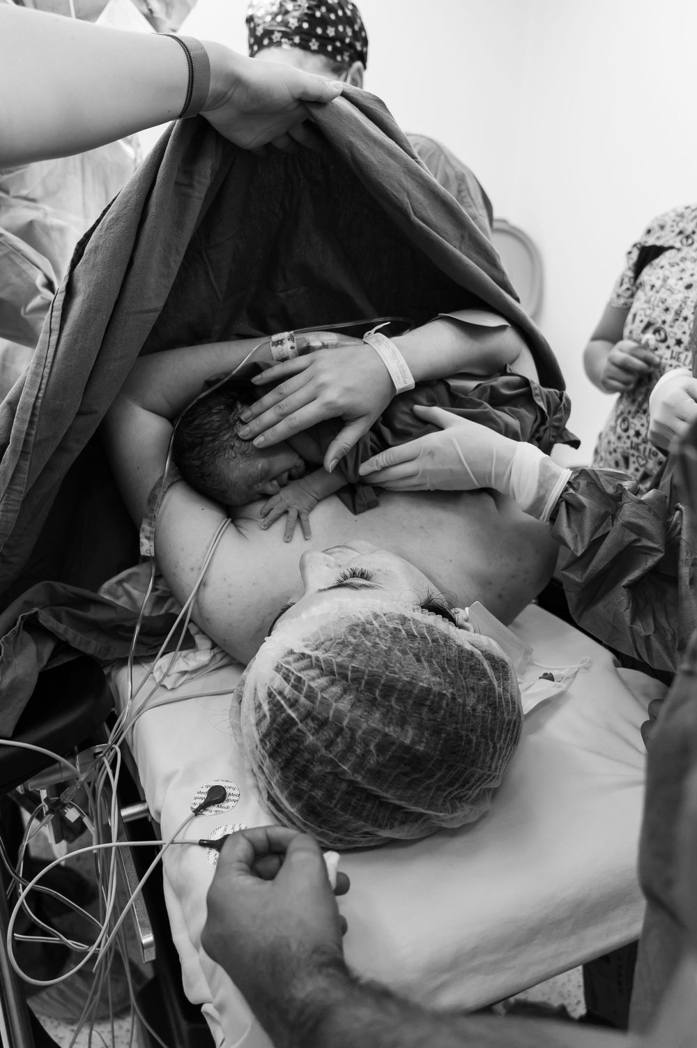 Medical professionals attending to a newborn baby during post-delivery care.