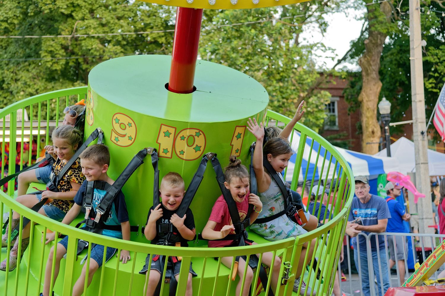 Children enjoying a colorful spinning carnival ride at an amusement park.