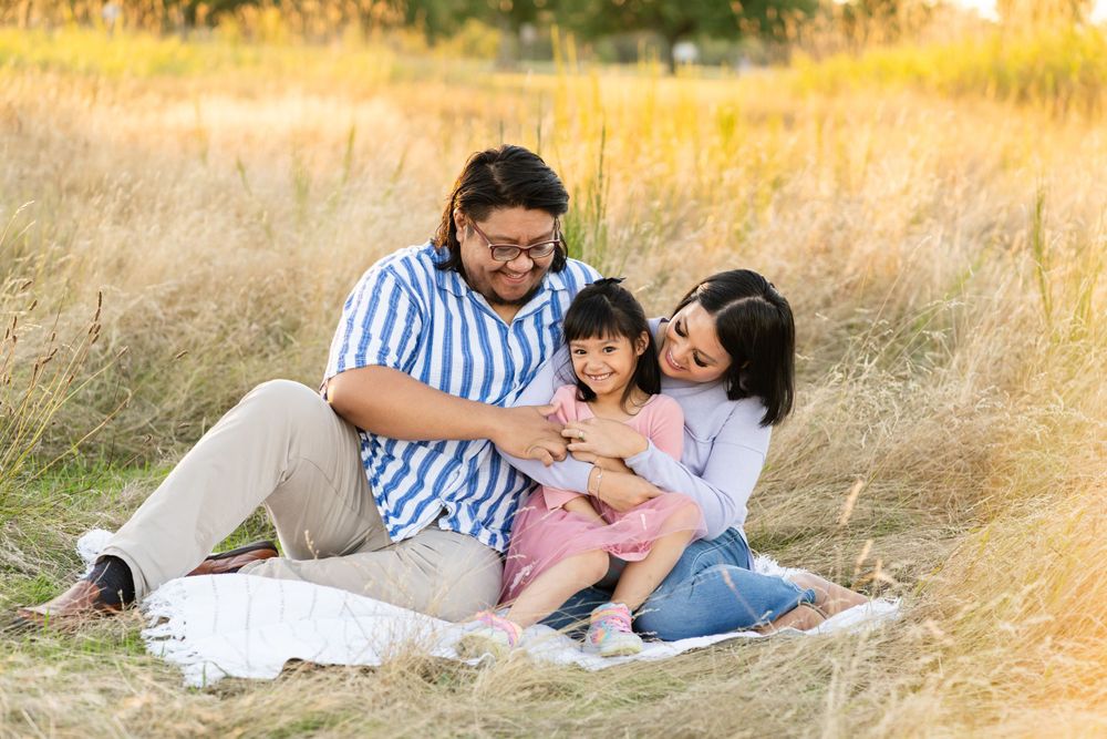 Family sitting on a blanket, tickling each other in Redmond.