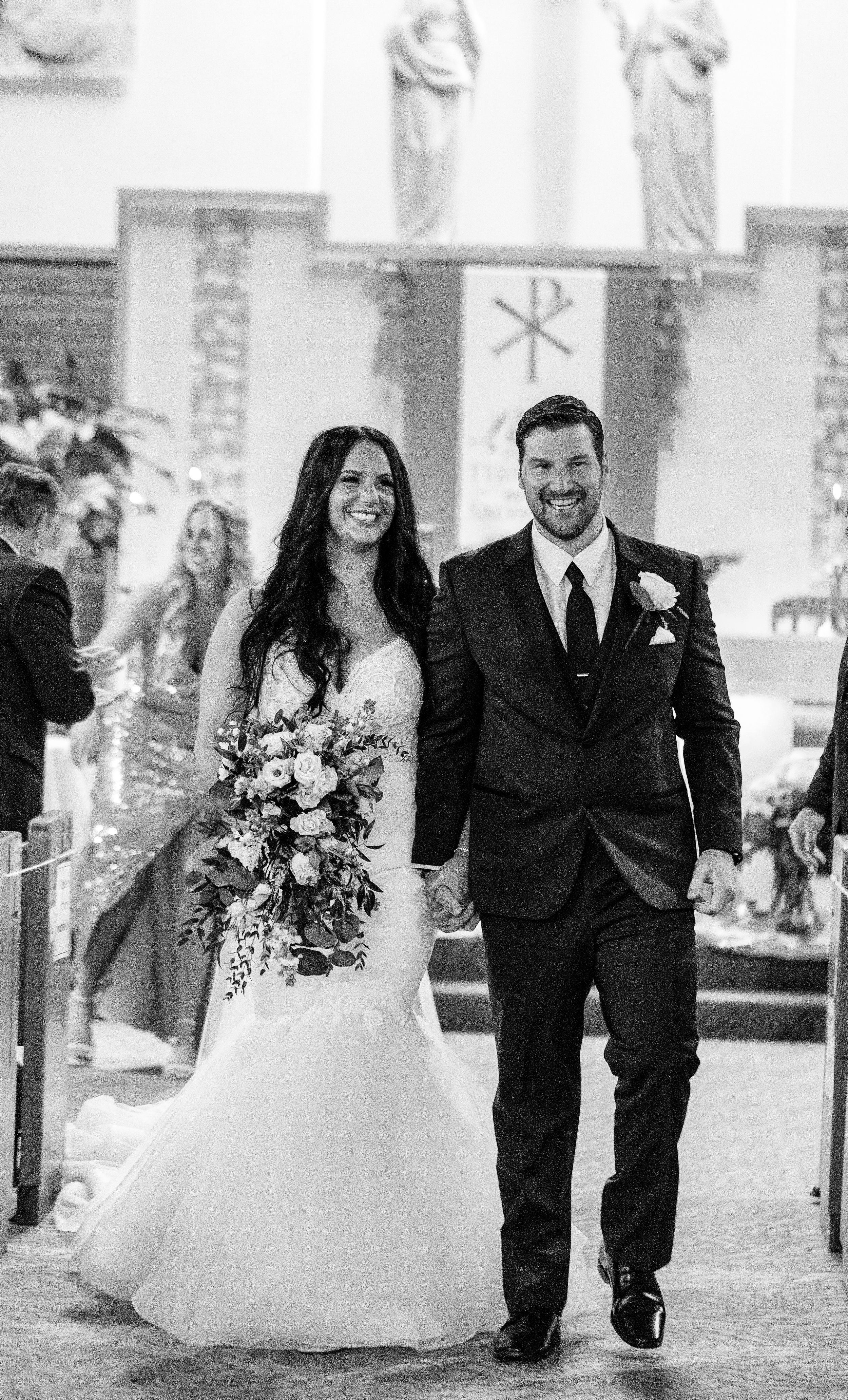 A couple walks down the church aisle after their wedding ceremony.