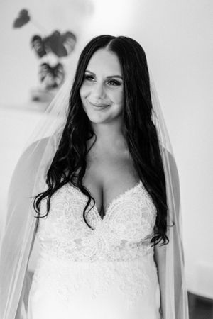 Bridal portrait in black and white featuring a lace wedding dress with veil.