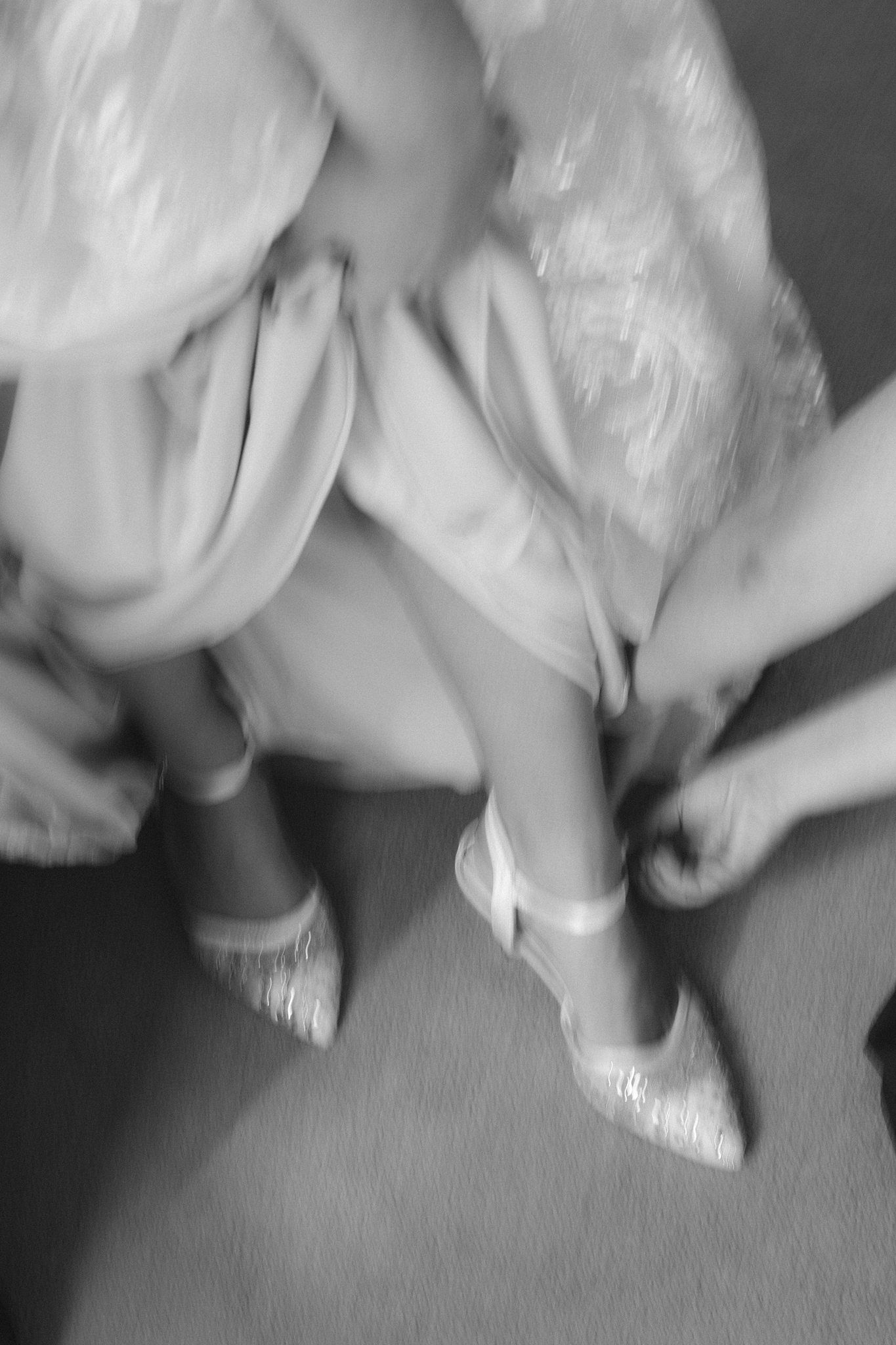 Blurred black and white image of elegant white heels and flowing fabric in motion at Whitepoint Resort, Nova Scotia