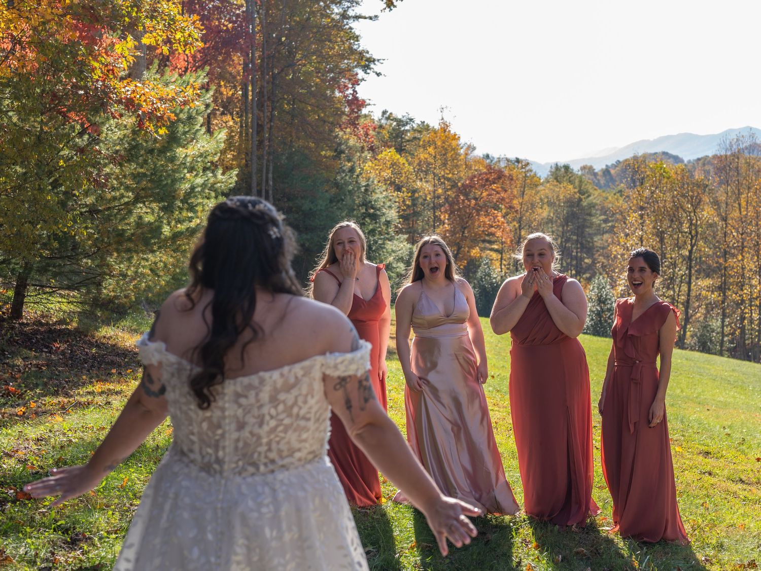 Wedding party in autumn colors sharing joyful moment in fall mountain scenery.