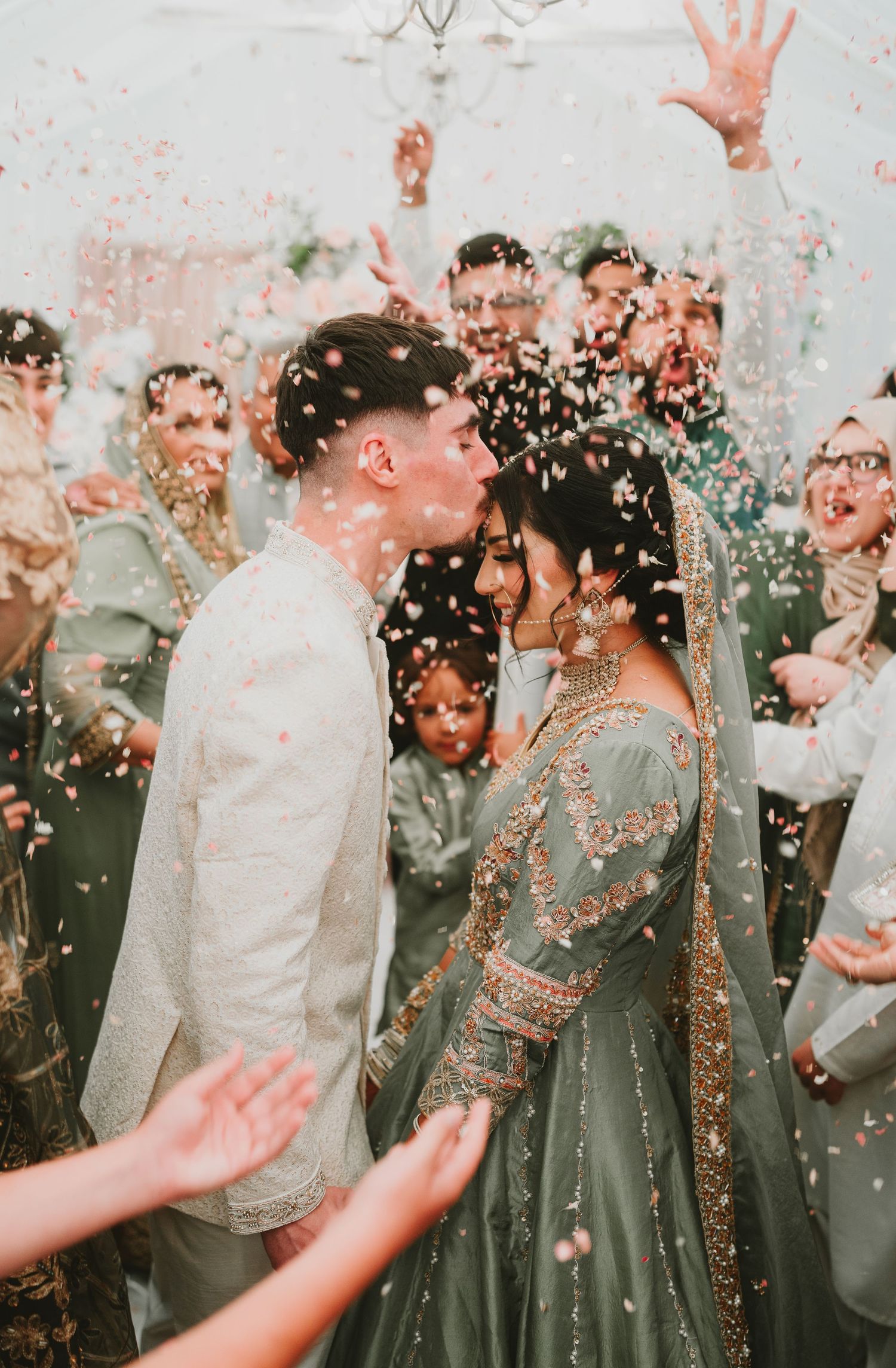 Joyful celebration with confetti shower during a fusion wedding ceremony.