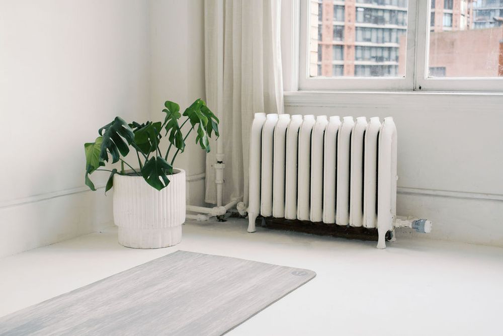 Minimalist white studio space with large windows and radiator.
