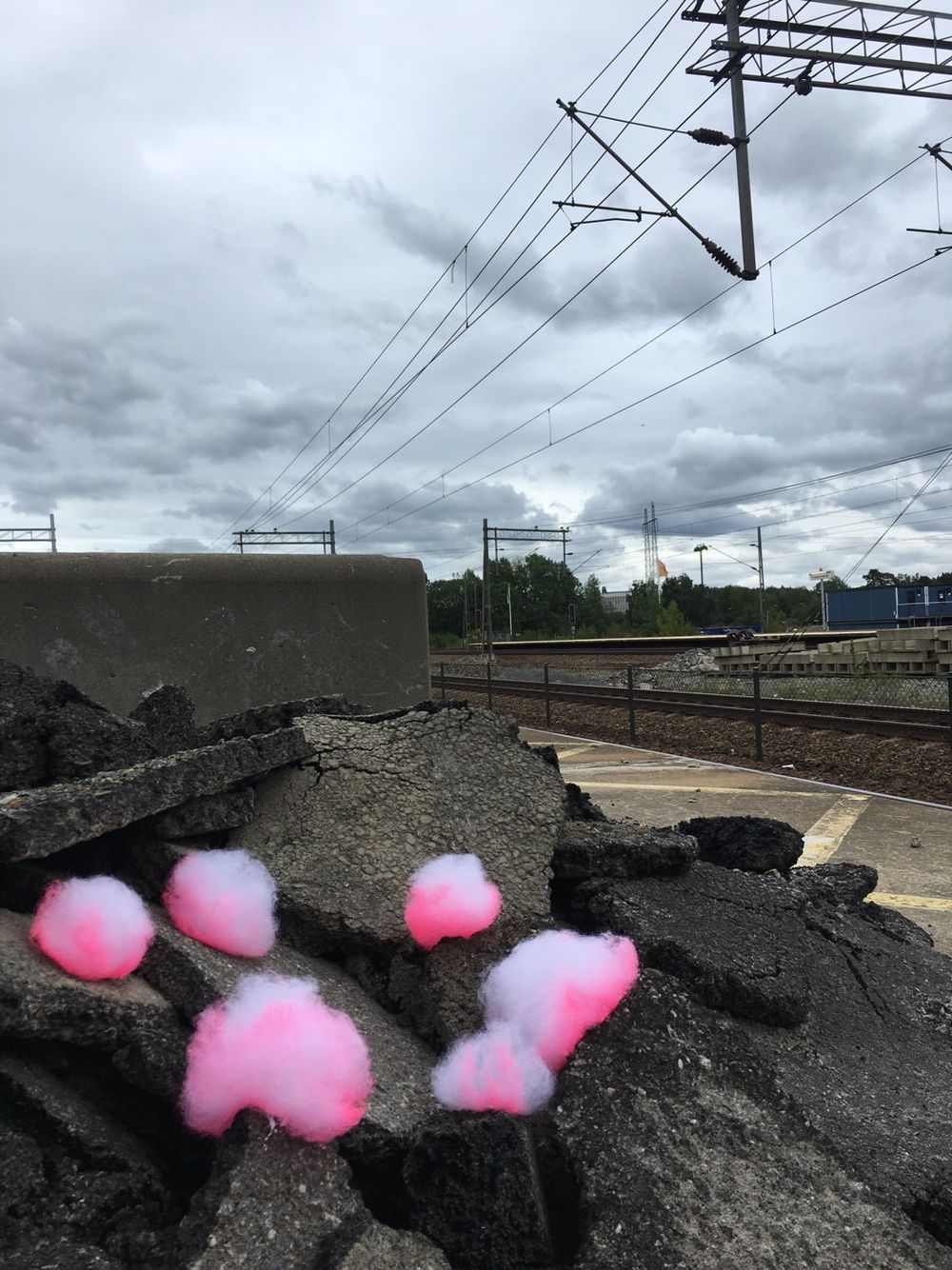 Neon pink little clouds an  pile of asphalt.