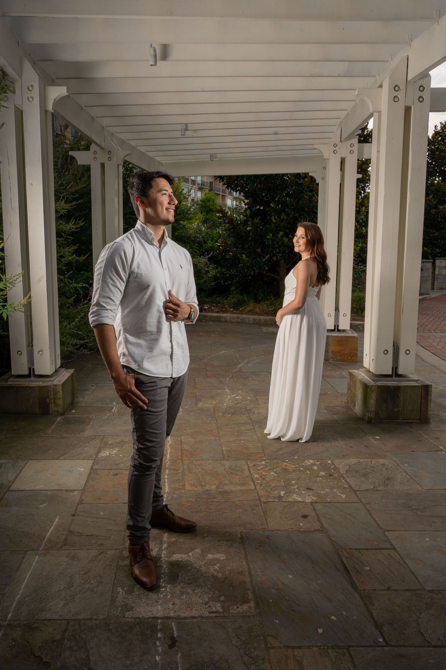 An artistic engagement photo captured under a white pergola walkway In Romare Bearden Park