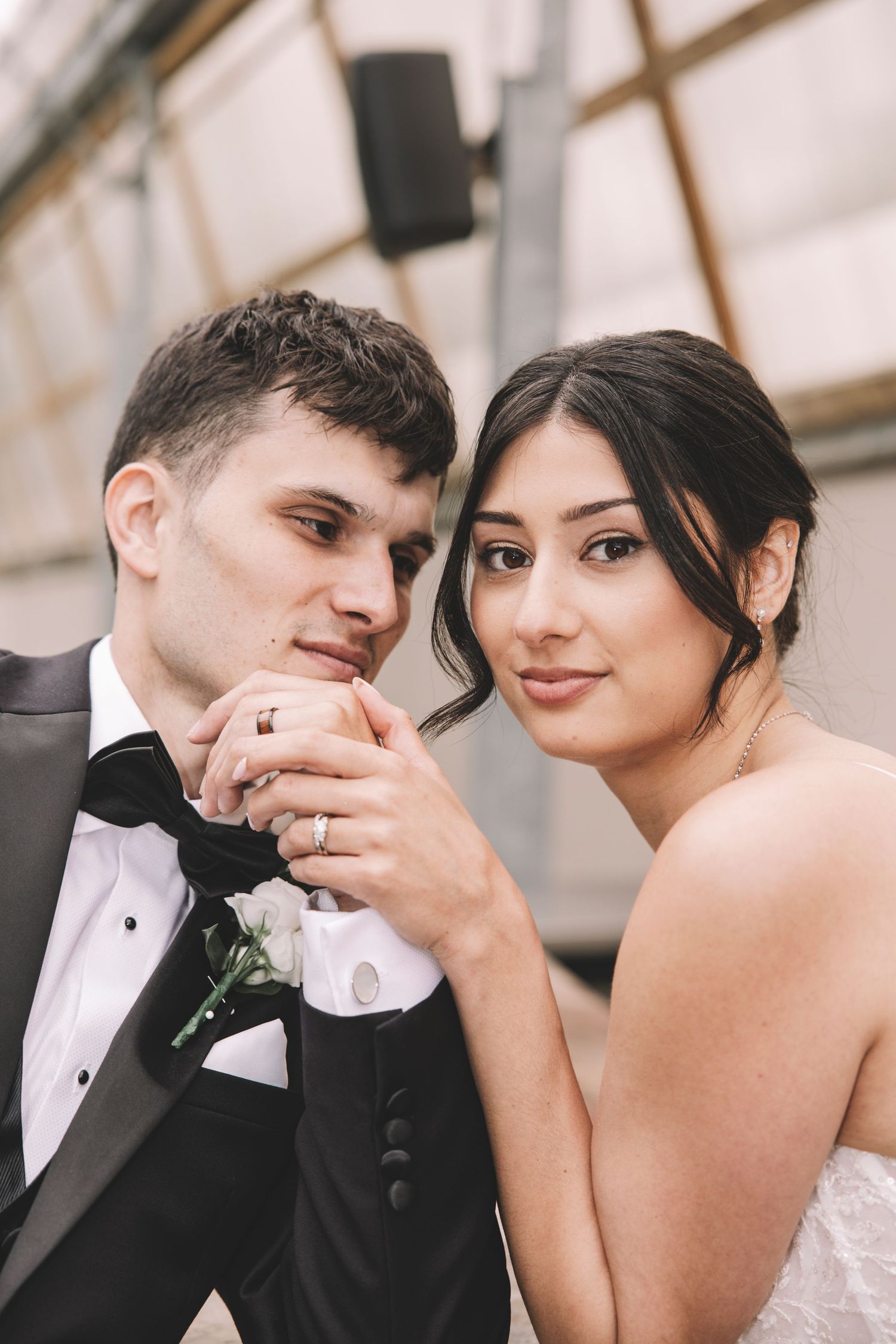 Romantic wedding portrait showing tender moment between newlyweds in formal attire.