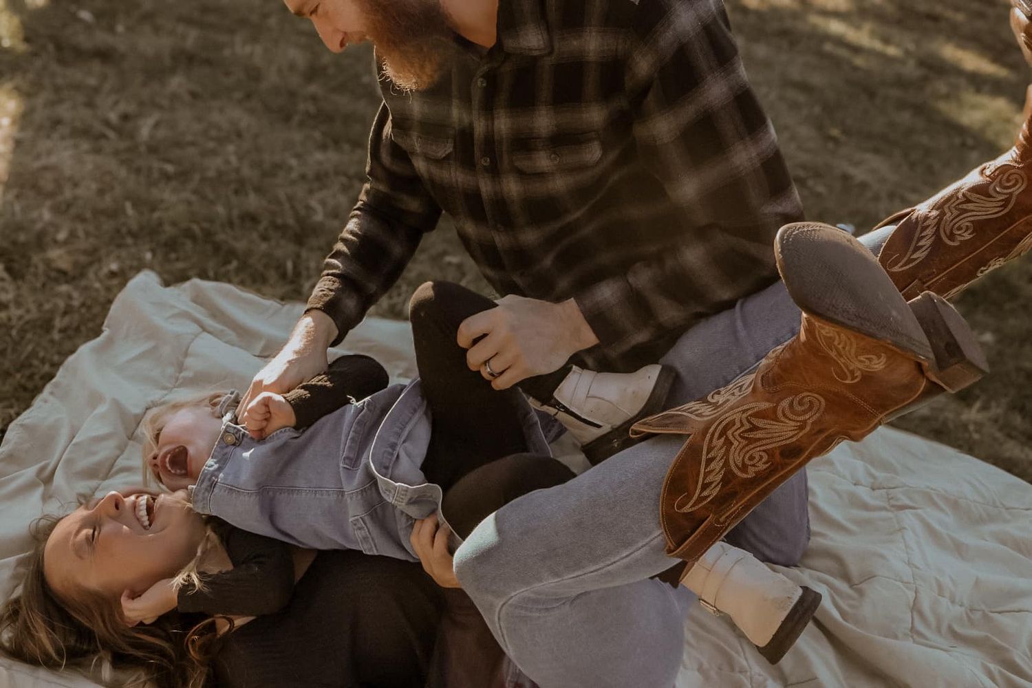 A romantic outdoor photo session capturing intimate moments between a couple on a blanket.