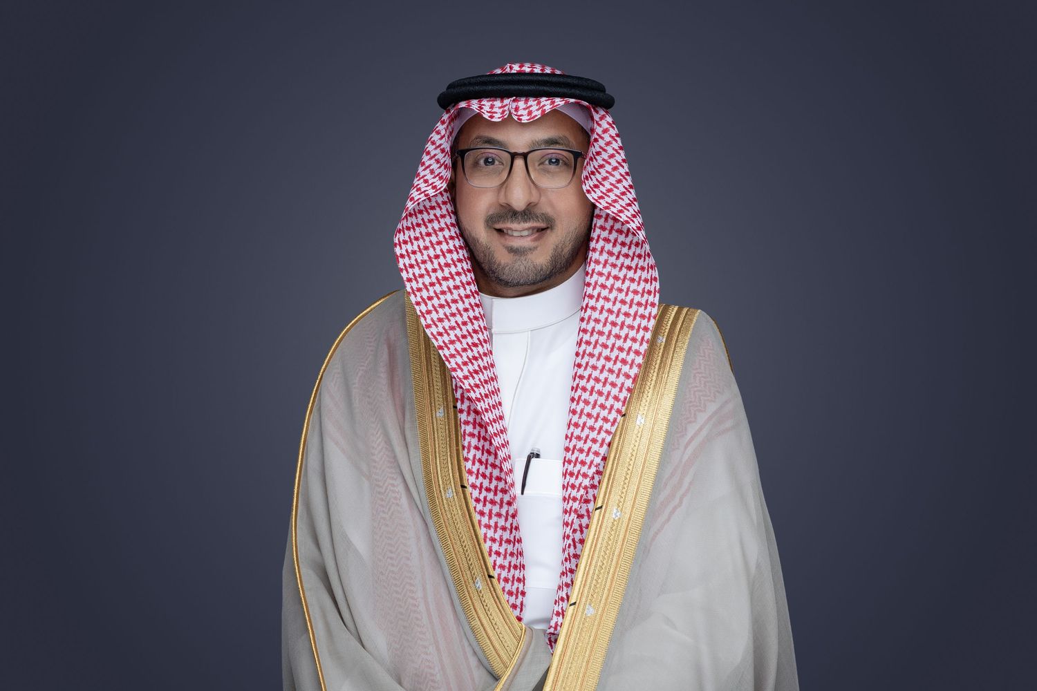 A person wearing traditional Middle Eastern attire including a white and red checkered headdress and light colored robe.