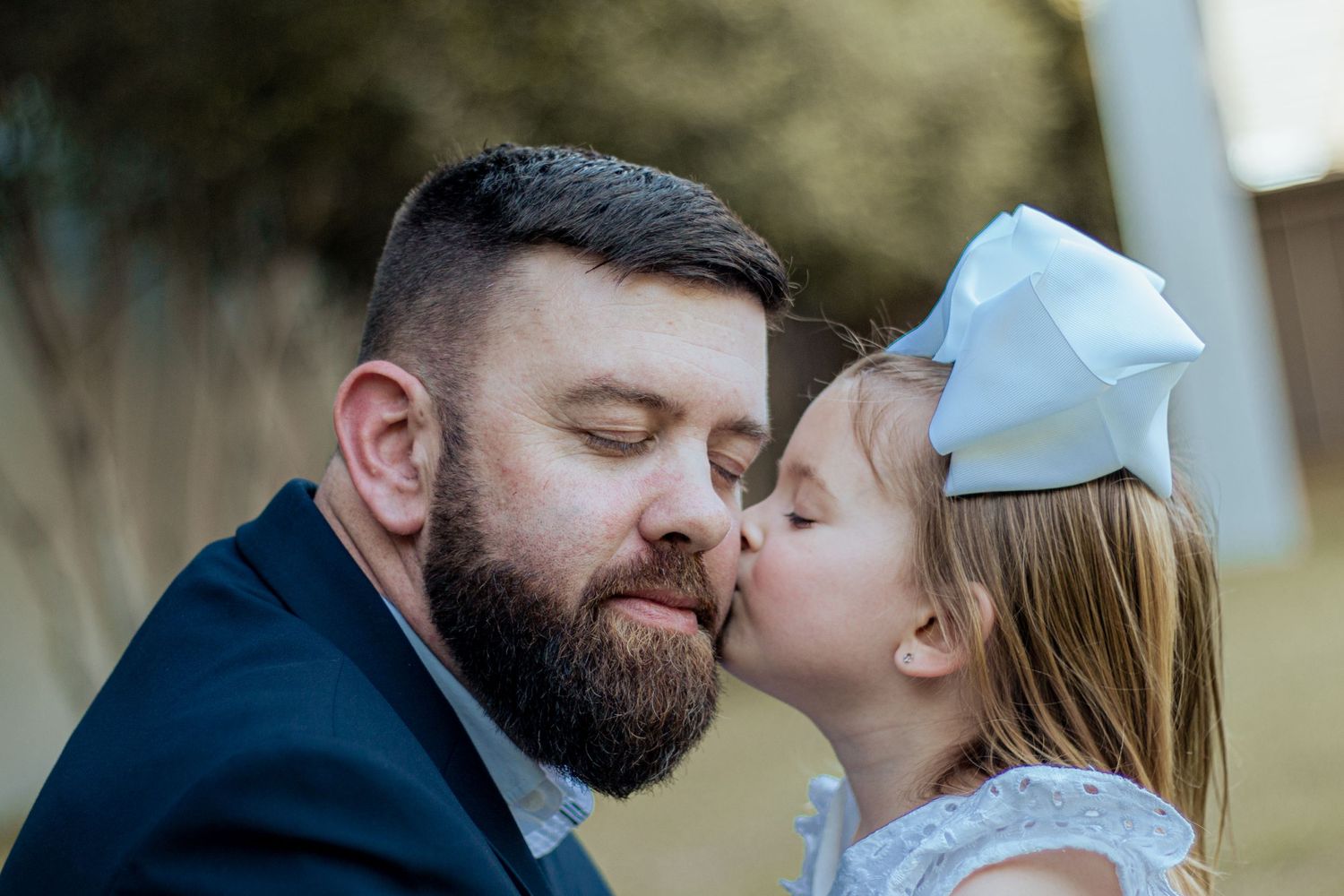 A tender moment between parent and child as they share an intimate whisper outdoors.