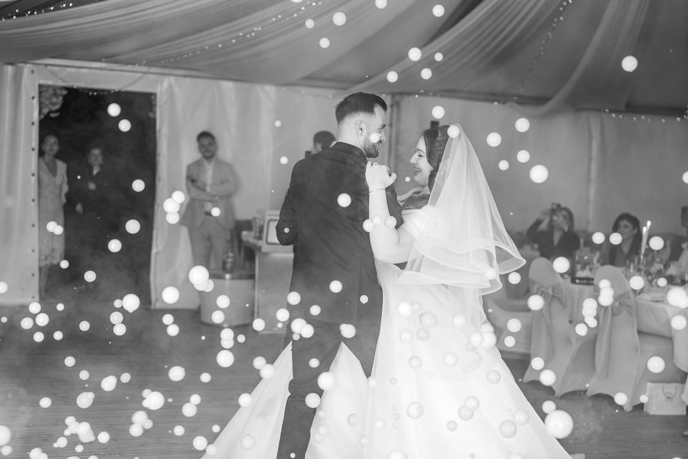 Braut und Bräutigam tanzen auf ihrer Hochzeit – klassische Schwarz-Weiß-Hochzeitsfotos voller Gefühl.