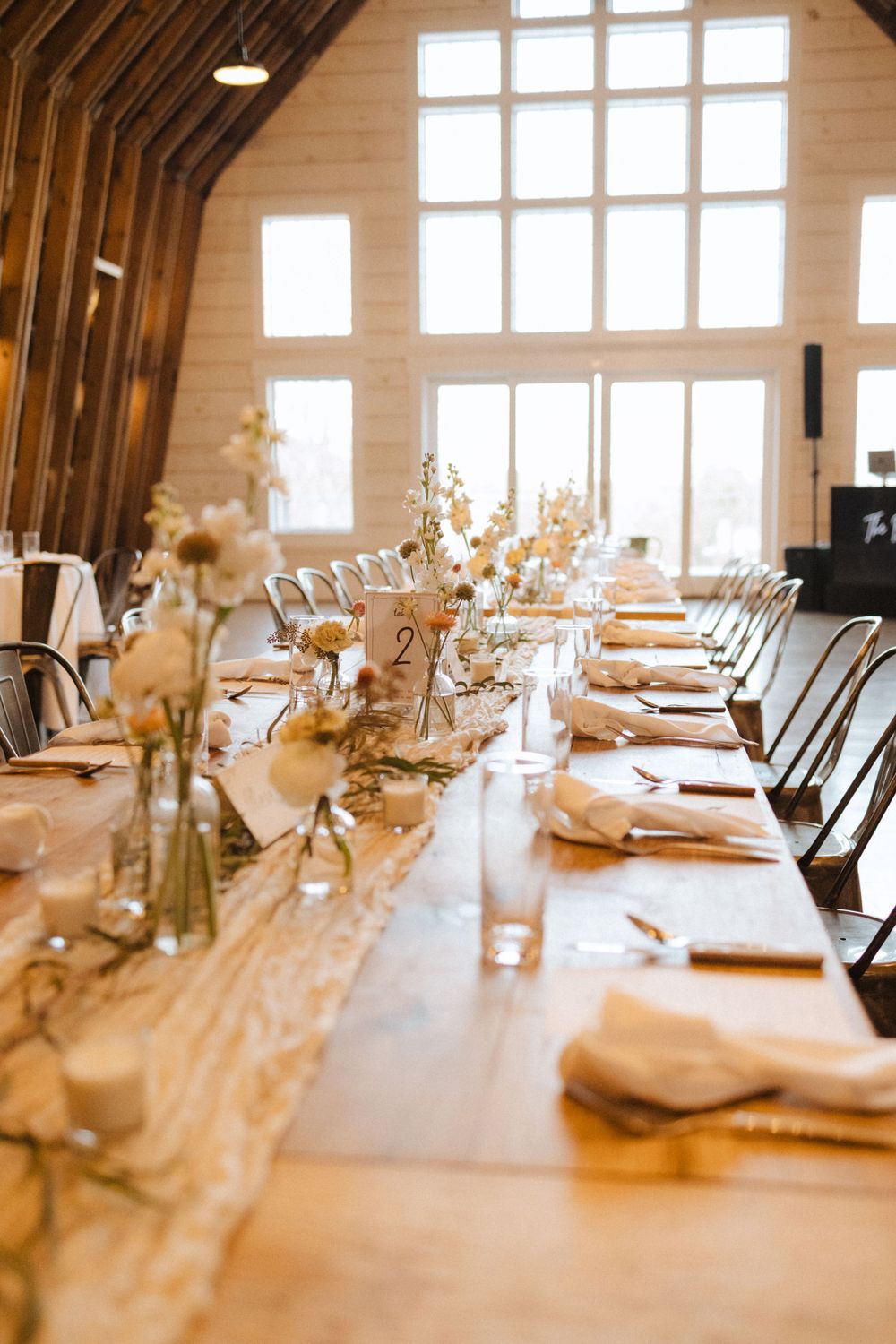 A rustic wedding reception table with elegant place settings and dried floral centerpieces in a bright farm near vernon nj.