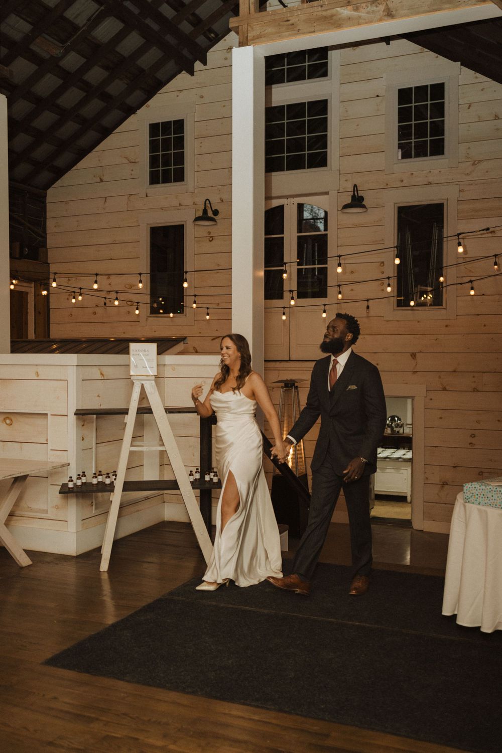 A wedding reception in a rustic barn venue with string lights and couples first dance near vernon nj.