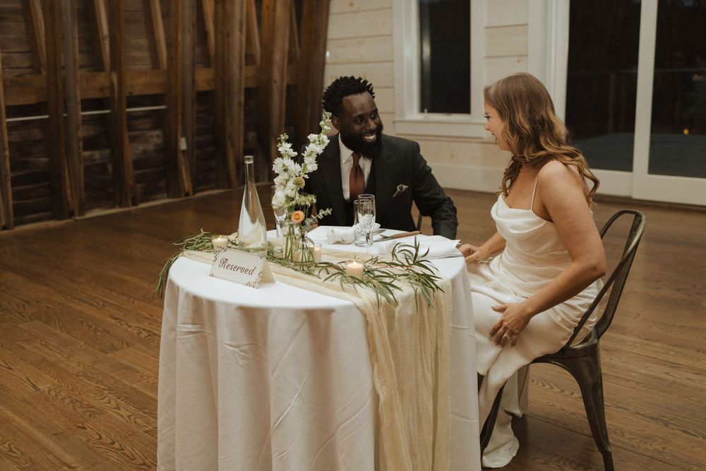 Two people share an intimate dinner at an elegantly decorated round table with white tablecloth and floral centerpiece near vernon nj.