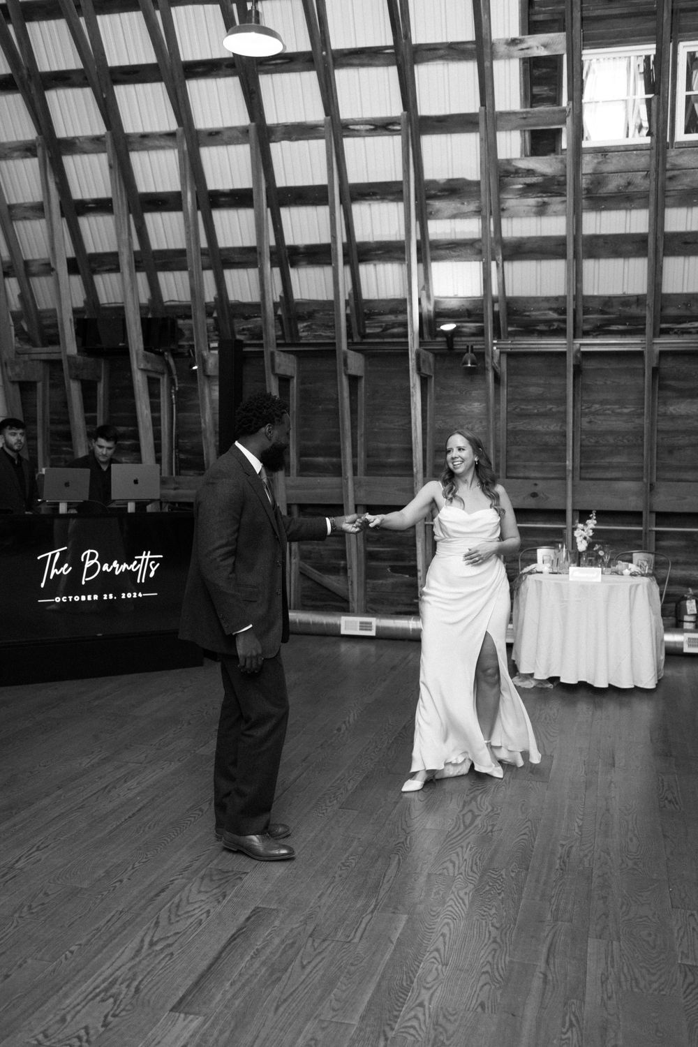 Black and white photo of a couple dancing together at a wedding reception in an elegant venue with wooden floors near vernon nj.