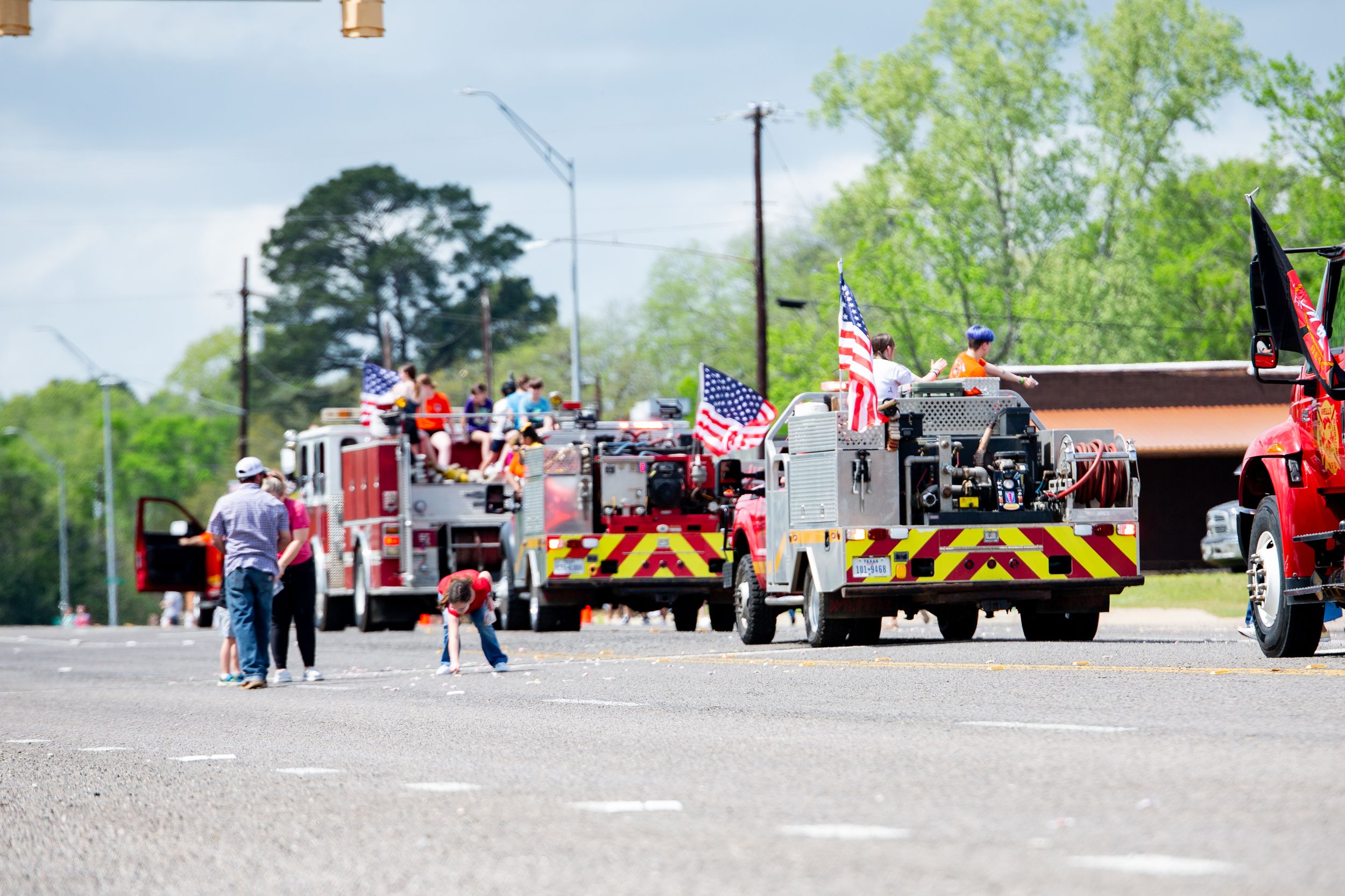 Row of emergency vehicles and fire trucks lined up at an outdoor event.