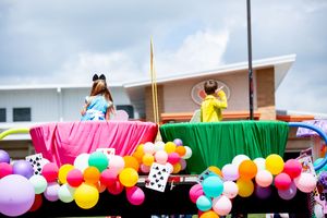 Festive parade float decorated with vibrant balloons and colorful fabric panels.