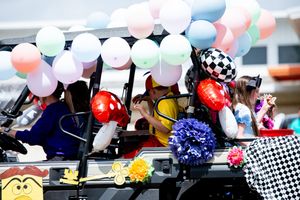 Festive decorations with colorful balloons and checkered flags at an outdoor celebration.