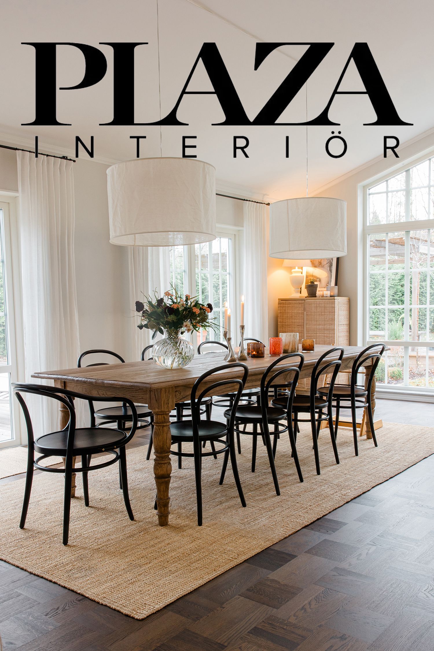 Elegant dining room with wooden table, black bentwood chairs, white drum pendant lights and jute rug on dark hardwood floors.
