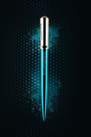 Coloressence teal metallic eyeliner pencil with silver cap, surrounded by turquoise powder burst on dark background.