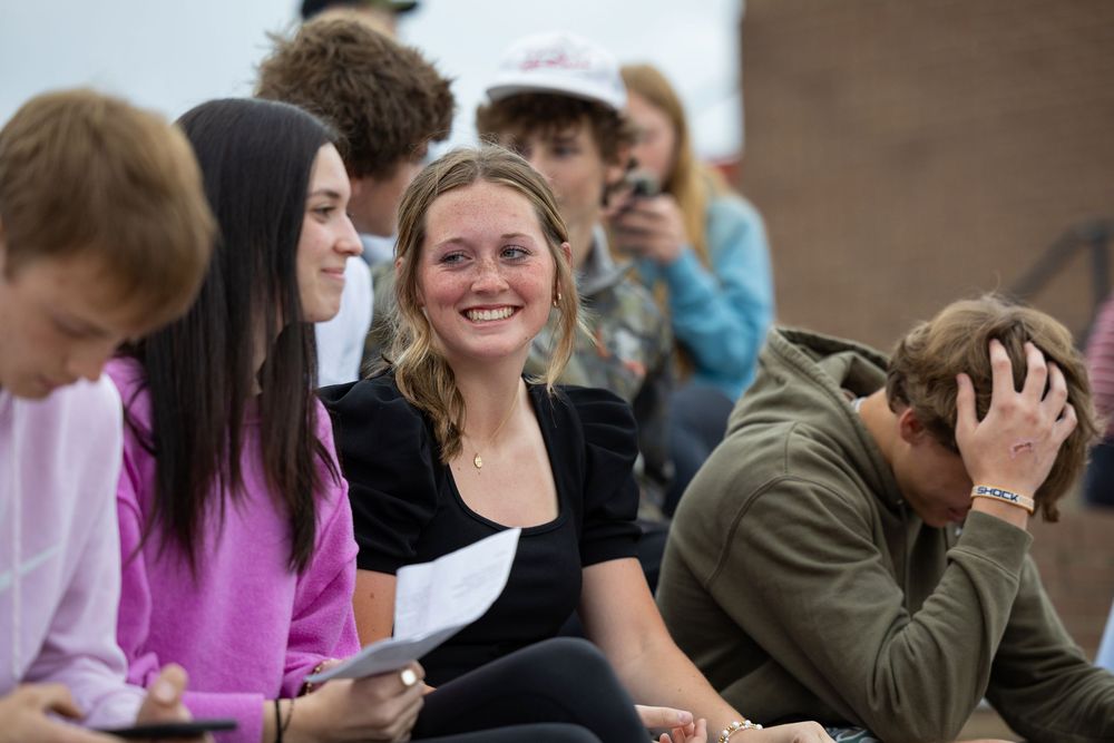 A group of young people sitting together and sharing a lighthearted moment during a casual gathering.