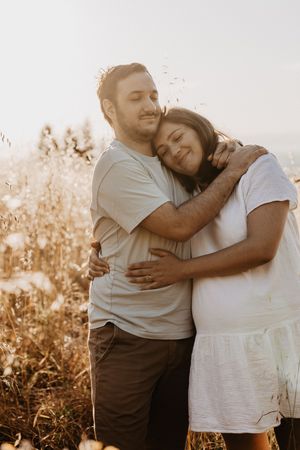 Tender moments captured in golden light among tall grass and wildflowers.