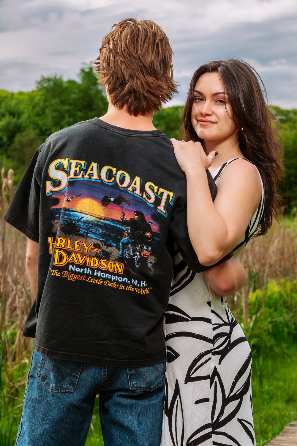 Couple in casual attire sharing romantic moment on nature trail.