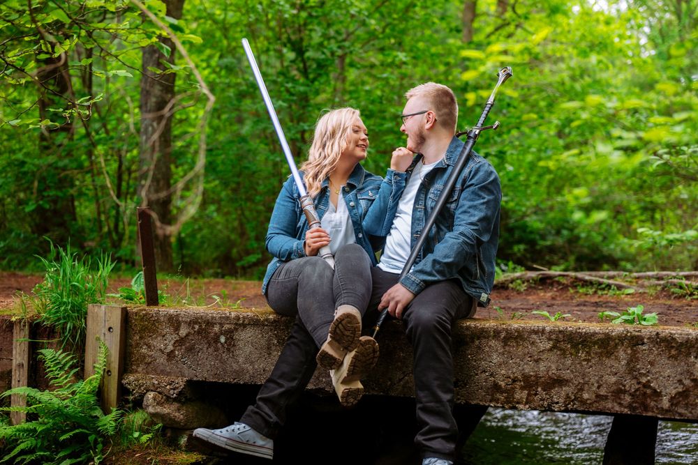 A couple shares intimate moments together in a lush green forest setting.