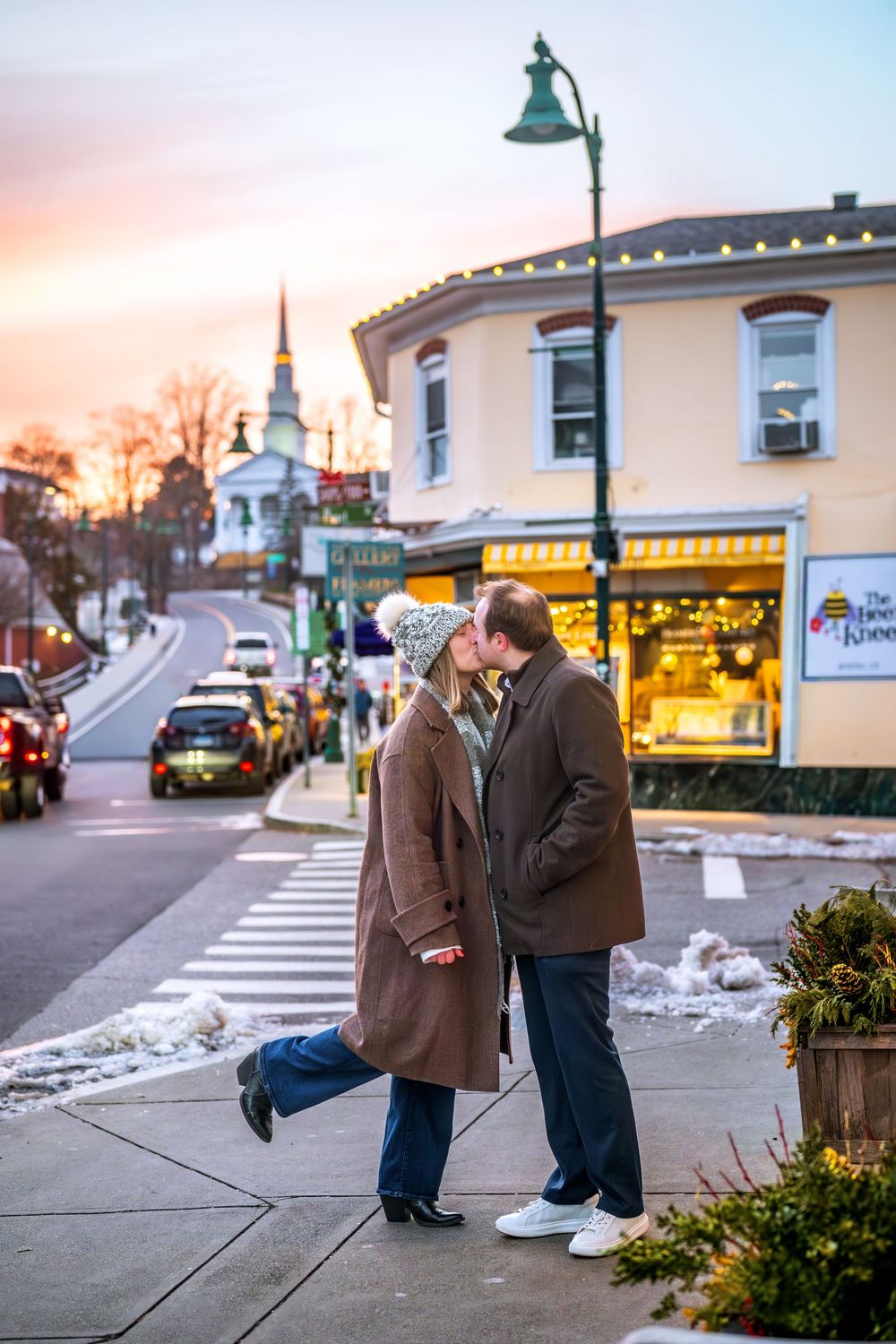Romantic street scene with couple embracing on winter evening in small town.