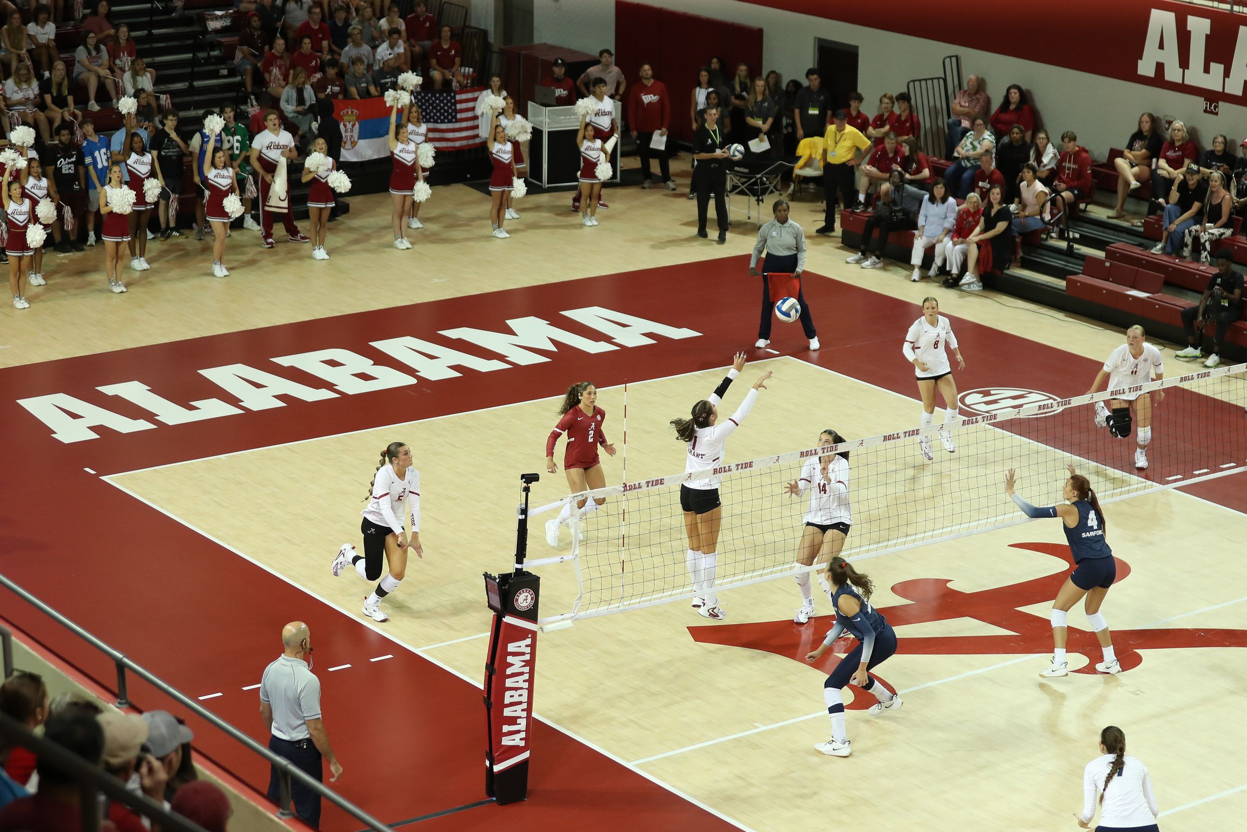 Alabama Crimson Tide volleyball team playing a home match in front of a packed crowd at Coleman Coliseum.