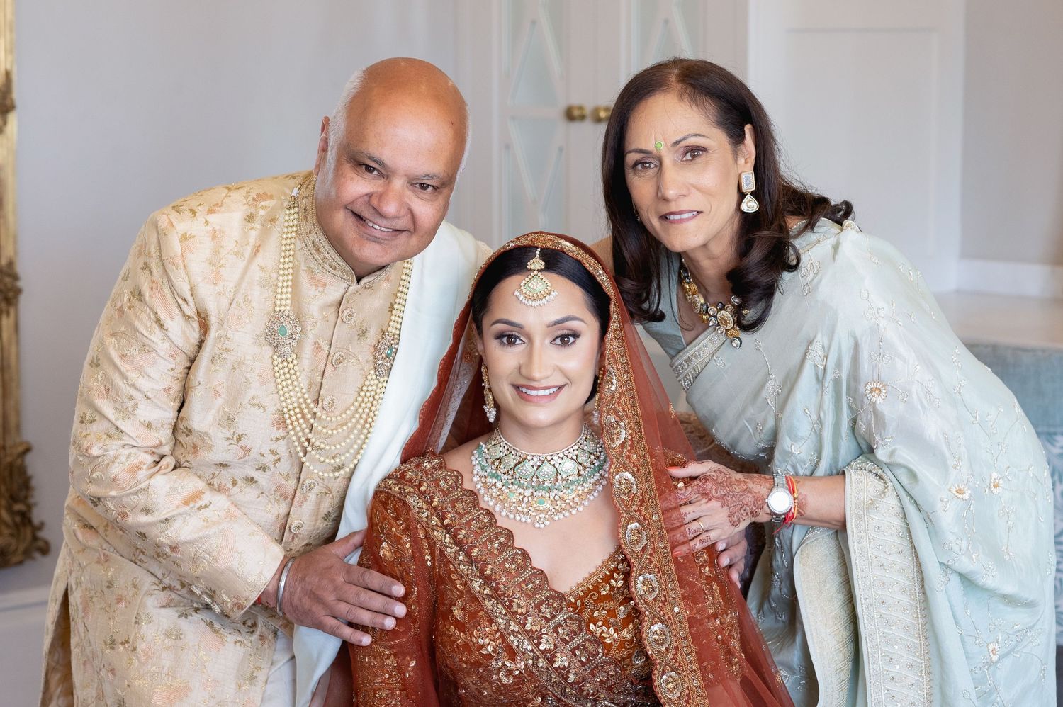 Traditional wedding celebration with family members in elegant Indian attire and jewelry.